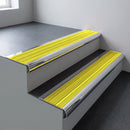 Polished aluminium bullnose stair nosing 66.5x30mm with Yellow Castellated insert fitted on an office stair