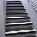 Black Anodised bullnose stair nosing 68x40mm with Porth Stone Smooth Textured insert, fitted to an interior stairwell