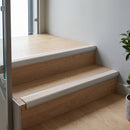 Aluminium bullnose stair nosing with a beige anti-slip insert fitted to light oak timber steps indoors