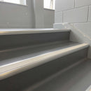 Aluminium bullnose stair nosing with a canvas anti-slip insert fitted to grey vinyl steps in a school stairwell