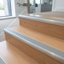 Aluminium bullnose stair nosing with a dolphin grey anti-slip insert fitted to light timber steps in an office reception