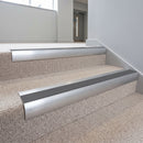 Aluminium bullnose stair nosing with a midnight grey anti-slip insert fitted to pale carpet steps in an office stair core