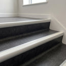Aluminium bullnose stair nosing with a white anti-slip insert fitted to dark vinyl steps in an internal stairwell