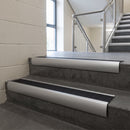 Aluminium bullnose stair nosing with Black Olympic Grip infill, fitted to concrete steps in a commercial stairwell