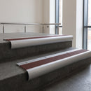 Aluminium bullnose stair nosing with Claret Castellated PVC infill, fitted to concrete steps in a commercial stairwell