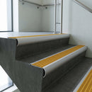 Aluminium bullnose stair nosing with Gold Castellated PVC infill, fitted to concrete steps in a commercial stairwell