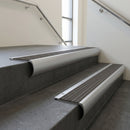 Aluminium bullnose stair nosing with Granite Castellated PVC infill, fitted to concrete steps in a commercial stairwell