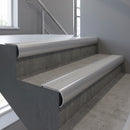 Aluminium bullnose stair nosing with Light Grey Castellated PVC infill, fitted to concrete steps in a commercial stairwell