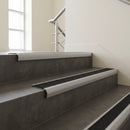 Mill Aluminium bullnose stair nosing with Black Olympic Grip infill, fitted to concrete steps in a commercial stairwell