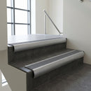 Mill Aluminium bullnose stair nosing with Flint Castellated PVC infill, fitted to concrete steps in a commercial stairwell