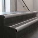 Mill Aluminium bullnose stair nosing with Granite Castellated PVC infill, fitted to concrete steps in a commercial stairwell