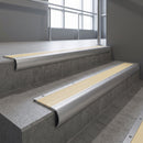 Mill Aluminium bullnose stair nosing with Ivory Castellated PVC infill, fitted to concrete steps in a commercial stairwell