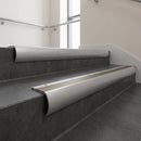 Mill Aluminium bullnose stair nosing with Light Bronze Anodised Aluminium infill, fitted to concrete steps in a commercial stairwell