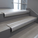 Mill Aluminium bullnose stair nosing with Light Grey Castellated PVC infill, fitted to concrete steps in a commercial stairwell