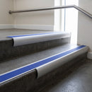 Mill Aluminium bullnose stair nosing with Mid Blue Castellated PVC infill, fitted to concrete steps in a commercial stairwell