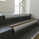 Mill Aluminium bullnose stair nosing with Olive Castellated PVC infill, fitted to concrete steps in a commercial stairwell