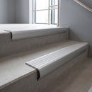 Mill Aluminium bullnose stair nosing with Polar Grey Castellated PVC infill, fitted to concrete steps in a commercial stairwell