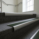 Mill Aluminium bullnose stair nosing with Spruce Castellated PVC infill, fitted to concrete steps in a commercial stairwell