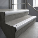 Mill Aluminium bullnose stair nosing with White Castellated PVC infill, fitted to concrete steps in a commercial stairwell