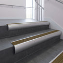 Aluminium bullnose stair nosing with Olive Castellated PVC infill, fitted to concrete steps in a commercial stairwell