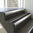 Polished Aluminium bullnose stair nosing with Black Smooth Textured PVC infill, fitted to concrete steps in a commercial stairwell