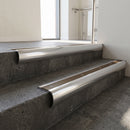 Polished Aluminium bullnose stair nosing with Bronze Anodised Aluminium infill, fitted to concrete steps in a commercial stairwell