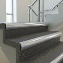 Polished Aluminium bullnose stair nosing with Flint Castellated PVC infill, fitted to concrete steps in a commercial stairwell