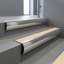 Polished Aluminium bullnose stair nosing with Ivory Castellated PVC infill, fitted to concrete steps in a commercial stairwell