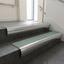 Polished Aluminium bullnose stair nosing with Jade Castellated PVC infill, fitted to concrete steps in a commercial stairwell