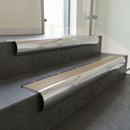 Polished Aluminium bullnose stair nosing with Light Bronze Anodised Aluminium infill, fitted to concrete steps in a commercial stairwell