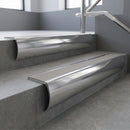 Polished Aluminium bullnose stair nosing with Light Grey Castellated PVC infill, fitted to concrete steps in a commercial stairwell