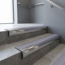 Polished Aluminium bullnose stair nosing with Nimbus Castellated PVC infill, fitted to concrete steps in a commercial stairwell