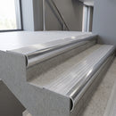 Polished Aluminium bullnose stair nosing with Polar Grey Castellated PVC infill, fitted to concrete steps in a commercial stairwell