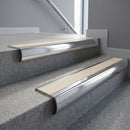 Polished Aluminium bullnose stair nosing with Porth Stone Castellated PVC infill, fitted to concrete steps in a commercial stairwell