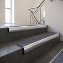 Polished Aluminium bullnose stair nosing with Regency Castellated PVC infill, fitted to concrete steps in a commercial stairwell