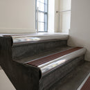 Polished Aluminium bullnose stair nosing with Rustic Castellated PVC infill, fitted to concrete steps in a commercial stairwell
