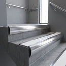 Polished Aluminium bullnose stair nosing with White Castellated PVC infill, fitted to concrete steps in a commercial stairwell