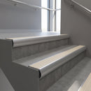 Aluminium bullnose stair nosing with Porth Stone Castellated PVC infill, fitted to concrete steps in a commercial stairwell