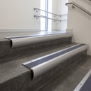 Aluminium bullnose stair nosing with Regency Castellated PVC infill, fitted to concrete steps in a commercial stairwell
