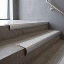 Aluminium bullnose stair nosing with White Castellated PVC infill, fitted to concrete steps in a commercial stairwell