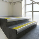Aluminium bullnose stair nosing with Yellow Castellated PVC infill, fitted to concrete steps in a commercial stairwell