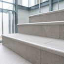 Matt silver aluminium bullnose tile-in stair nosing with ribbed grip edge fitted to porcelain-tiled steps