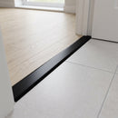 38mm aluminium cover strip in Onyx Black fitted in an apartment doorway between pale oak LVT and light grey tile