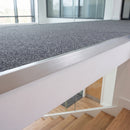 Satin silver mill aluminium landing strip fitted along the edge of a carpeted landing above a staircase