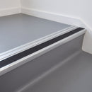 Aluminium ramp trim fitted behind a heavy duty stair nosing on a vinyl floored stair landing