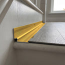 Gold anodised aluminium inner corner trim closing the internal angle between an LVT stair tread and the riser