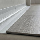 Close-up of the ribbed inner face and countersunk fixing holes with the LVT plank edge seated in the 5mm recess