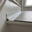 Silver anodised aluminium inner corner trim fitted at the back of an LVT stair tread against the painted riser