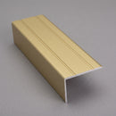 Matt brass aluminium stair nosing 25mm x 10mm shown alone on a plain studio background, L-angle and grooved top face visible