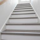 Slim matt silver aluminium stair nosing 25mm x 10mm fitted along the front edge of every step on a grey laminate staircase